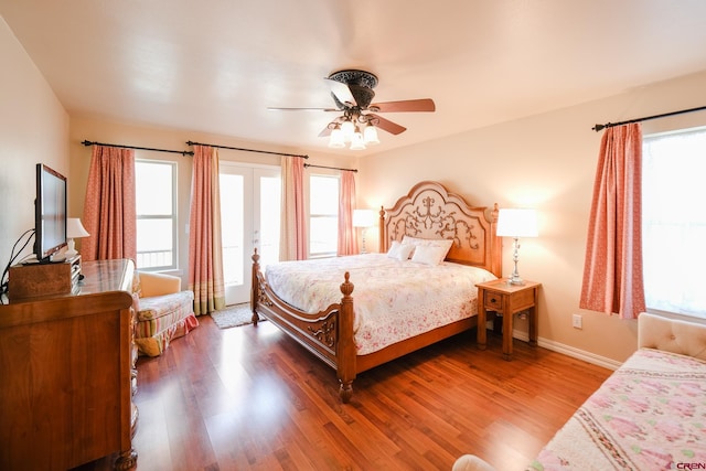 bedroom featuring multiple windows, wood-type flooring, and ceiling fan