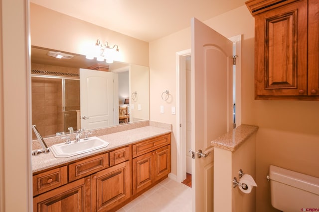 bathroom with vanity, tile patterned floors, toilet, and an enclosed shower