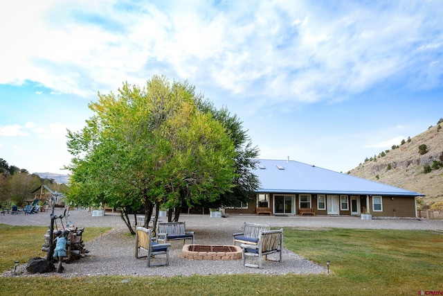 rear view of property featuring a yard and a mountain view