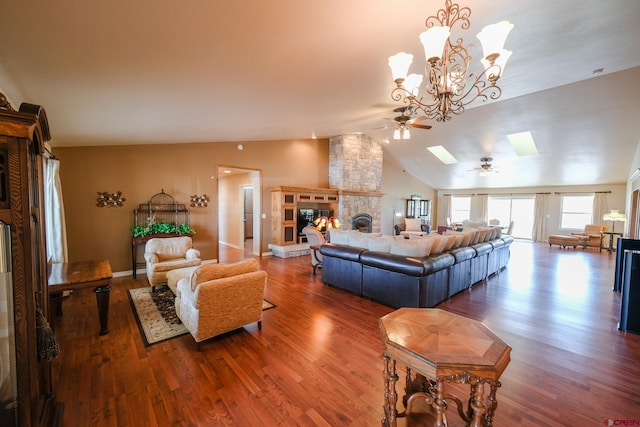 living room with lofted ceiling with skylight, a fireplace, ceiling fan with notable chandelier, and hardwood / wood-style floors