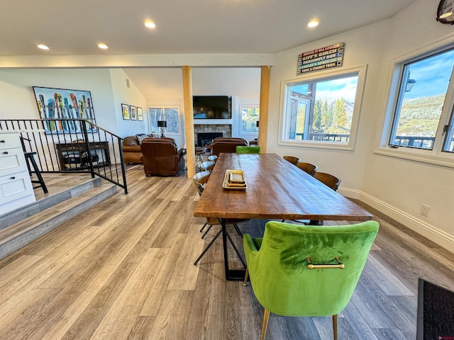 dining area featuring lofted ceiling and light hardwood / wood-style flooring