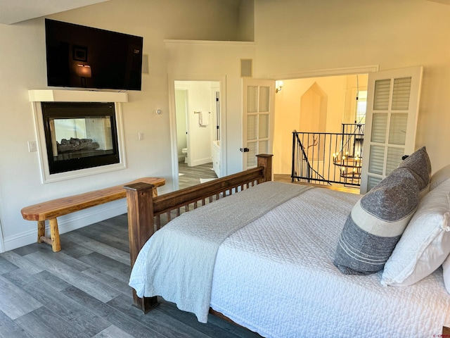 bedroom with hardwood / wood-style floors and ensuite bathroom