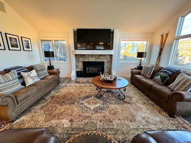 living room with vaulted ceiling, a fireplace, and wood-type flooring