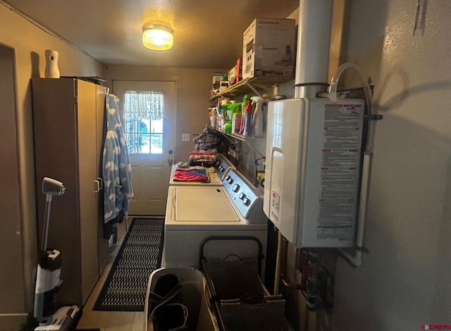 kitchen featuring independent washer and dryer, water heater, and tile patterned floors