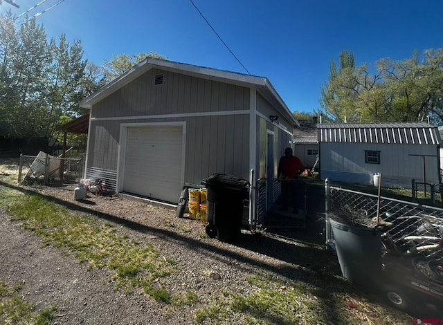 view of side of home featuring an outbuilding and a garage