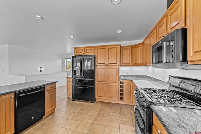 kitchen with black appliances, dark stone countertops, and light tile patterned floors