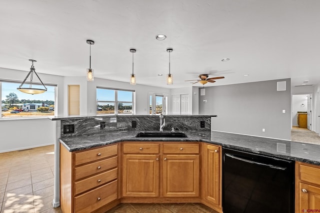 kitchen with sink, dishwasher, and dark stone countertops