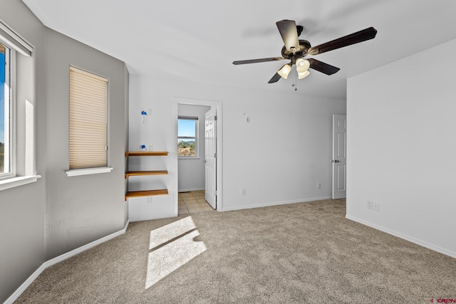 spare room with light colored carpet and ceiling fan