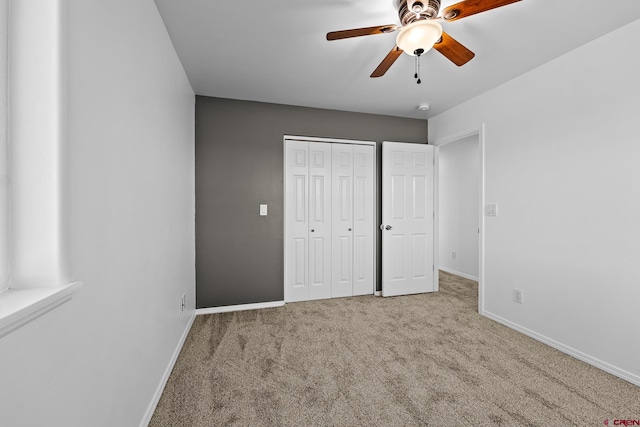 unfurnished bedroom featuring a closet, ceiling fan, and light colored carpet