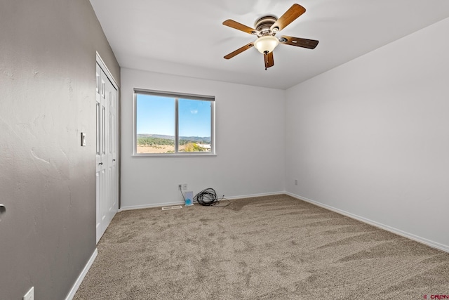 empty room featuring ceiling fan and carpet flooring