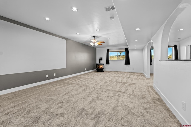 carpeted home theater room with ceiling fan