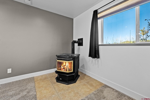 room details featuring a wood stove and tile patterned flooring