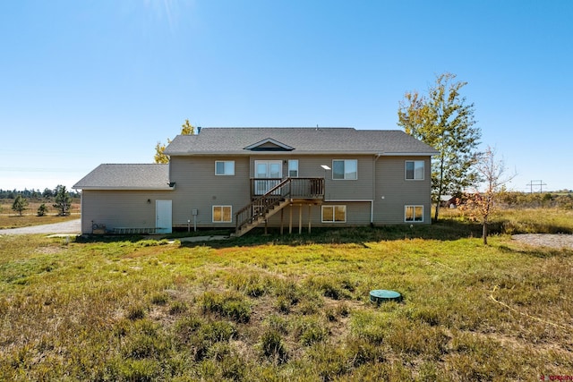 rear view of property with a yard and a deck