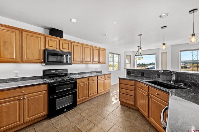 kitchen featuring a healthy amount of sunlight, black appliances, and hanging light fixtures