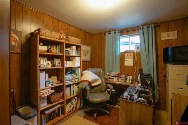 carpeted home office featuring wood walls