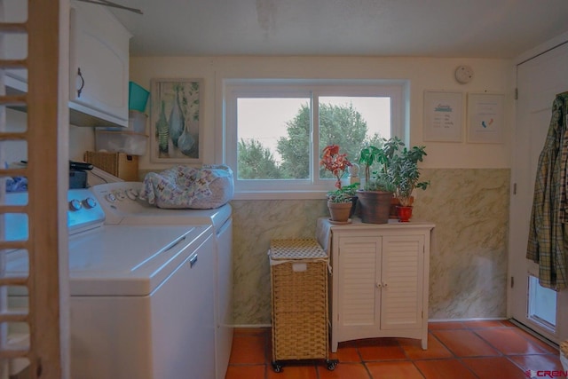 laundry room with washer and clothes dryer, light tile patterned floors, and cabinets