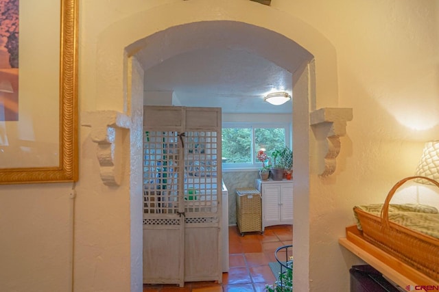 corridor featuring tile patterned floors and a textured ceiling