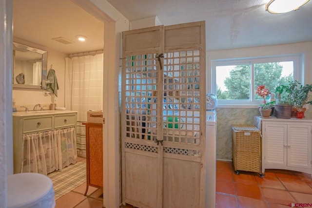 bathroom with tile walls, sink, and tile patterned flooring