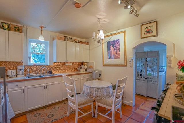 kitchen with decorative backsplash, white cabinetry, and pendant lighting