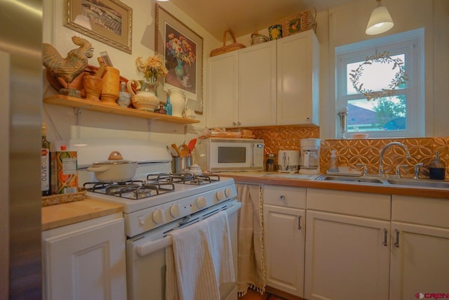 kitchen with white cabinets, tasteful backsplash, pendant lighting, sink, and white appliances