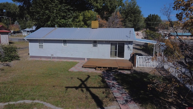 back of property featuring a yard and a deck