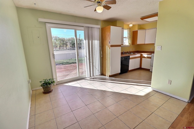 kitchen with white cabinets, a textured ceiling, and plenty of natural light