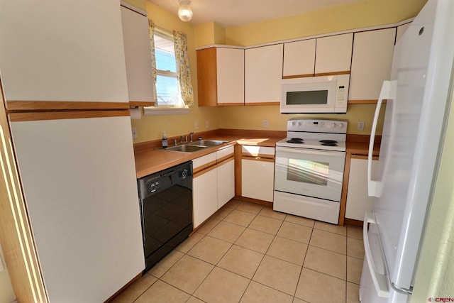 kitchen with light tile patterned flooring, white cabinets, sink, and white appliances