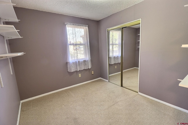 unfurnished bedroom with a closet, a textured ceiling, and carpet flooring