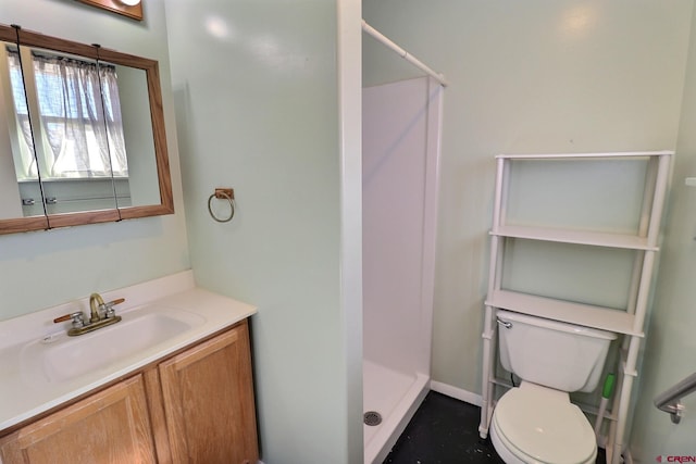 bathroom featuring vanity, a shower, and toilet