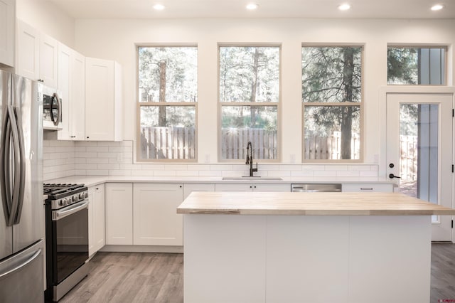 kitchen featuring appliances with stainless steel finishes, white cabinets, sink, and a wealth of natural light