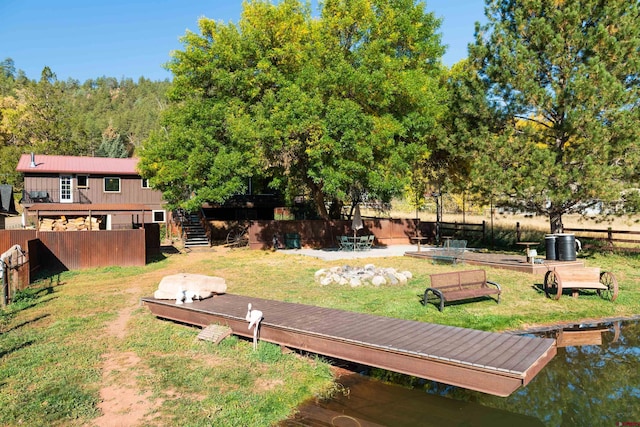 exterior space featuring a deck with water view and a dock