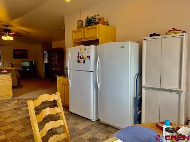 kitchen with light brown cabinets, vaulted ceiling, ceiling fan, and white refrigerator