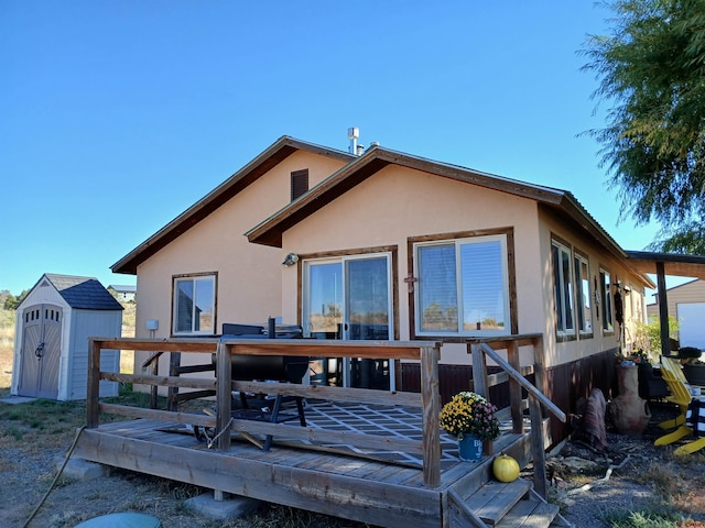 rear view of house with a shed and a wooden deck