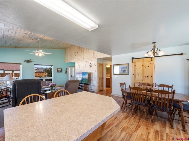 interior space featuring a barn door, wooden ceiling, vaulted ceiling, light hardwood / wood-style flooring, and ceiling fan with notable chandelier