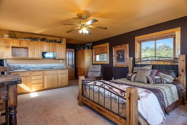 carpeted bedroom featuring ceiling fan and sink