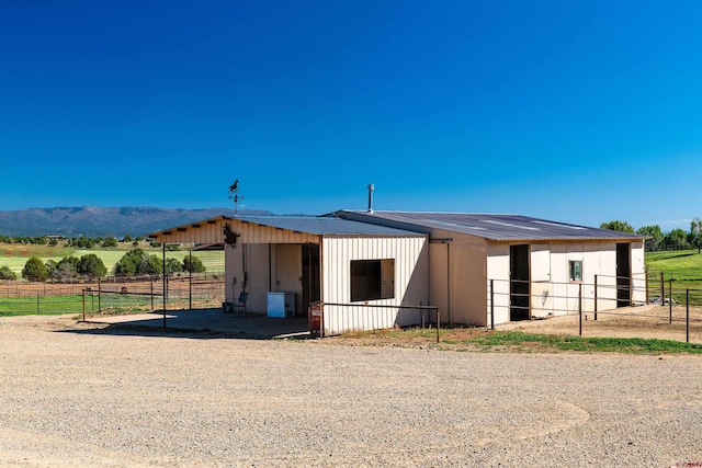 view of stable with a mountain view and a rural view