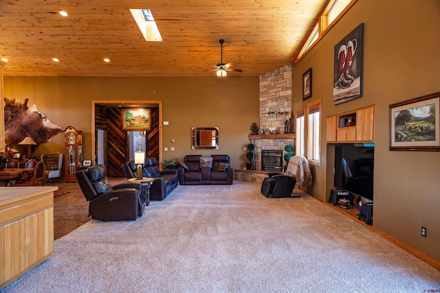 living room with wood ceiling, ceiling fan, carpet floors, a high ceiling, and a fireplace