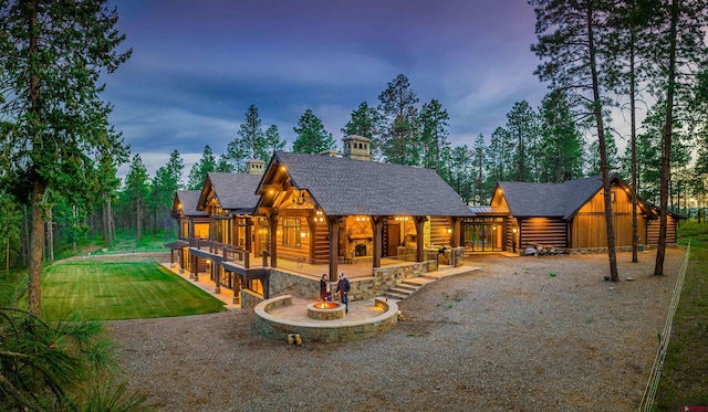 log-style house with a patio and a lawn