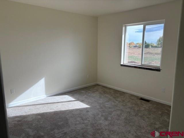 unfurnished room featuring dark colored carpet