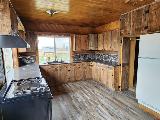 kitchen featuring wood walls, sink, dark wood-type flooring, and white appliances