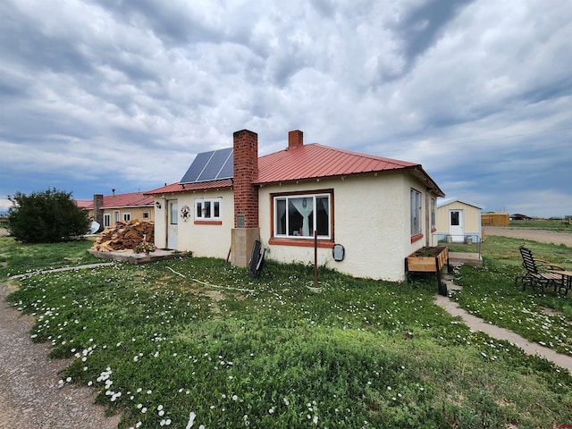 view of property exterior featuring a lawn and solar panels