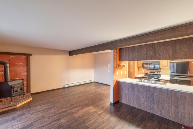 kitchen featuring dark wood-type flooring, black appliances, a baseboard radiator, and a wood stove