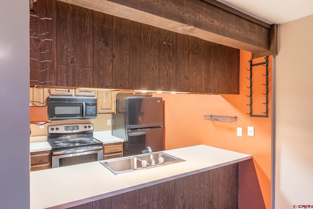 kitchen featuring refrigerator, sink, and stainless steel electric range oven