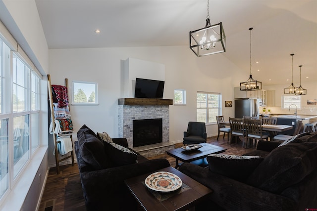 living room featuring lofted ceiling, dark wood-type flooring, a fireplace, and sink