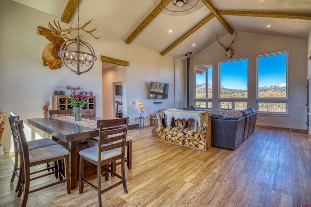 dining space featuring light hardwood / wood-style flooring, beam ceiling, and a chandelier