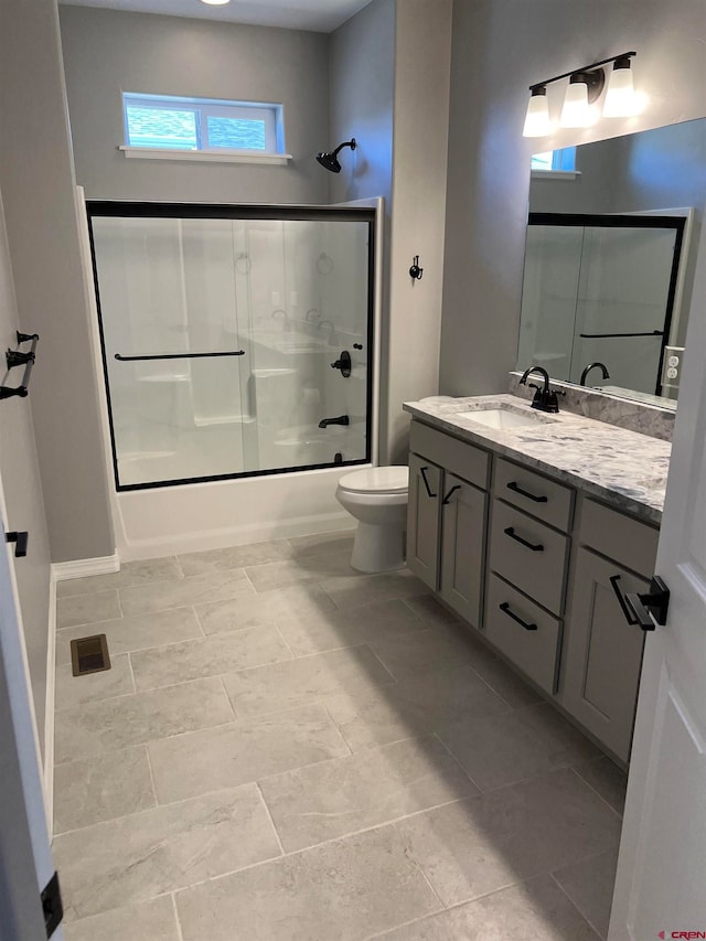 full bathroom featuring vanity, toilet, and combined bath / shower with glass door