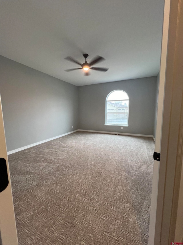 carpeted empty room featuring ceiling fan