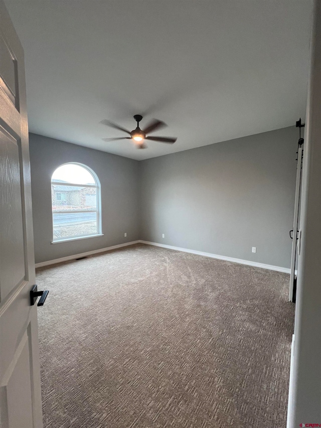 unfurnished room with carpet floors and ceiling fan