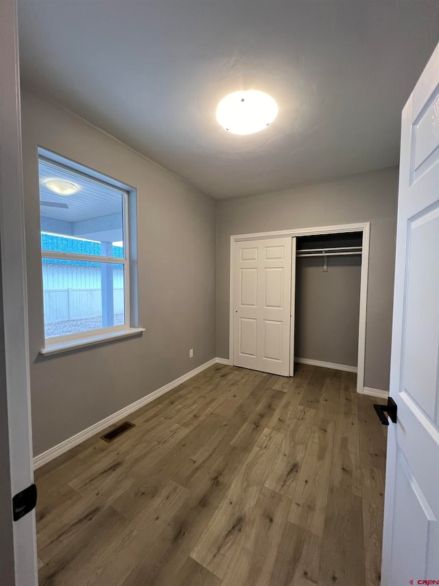 unfurnished bedroom with wood-type flooring and a closet