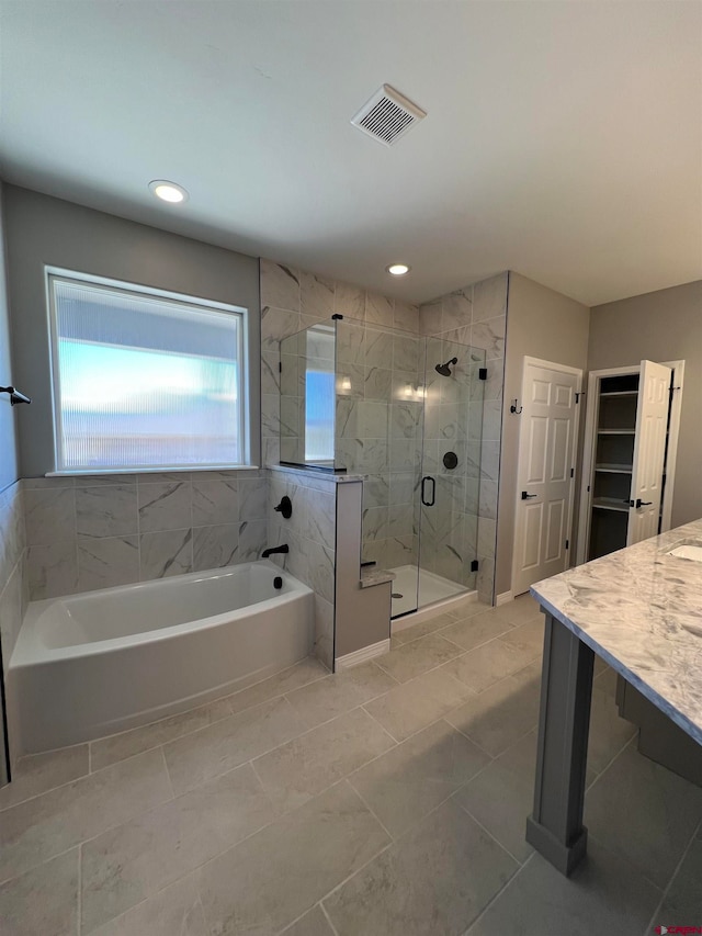 bathroom featuring vanity and shower with separate bathtub